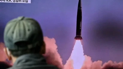 2021年10月19日、ソウルの鉄道駅で、北朝鮮のミサイル実験のアーカイブ映像を使ったニュース番組を流すテレビ報道を見る男性。afp - アンソニー・ウォレス