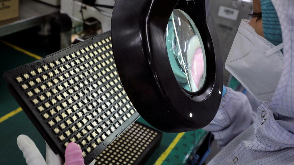 労働者がマレーシアのチップ包装会社Uniisemで半導体チップを検査(イラストレーション)ロイター - LIM HUEY TENG