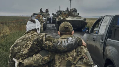 ウクライナ・ハリコフ地方の解放区で、道路上で負傷した兵士を助けるウクライナ兵（2022年9月12日、月曜日）。AP - Kostiantyn Liberov