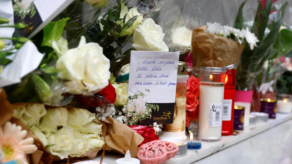 12歳の若いローラが住んでいたパリの建物の前には、花、手書きの言葉、ろうそくが置かれています。© ロイター/ゴンサロ・フエンテス
