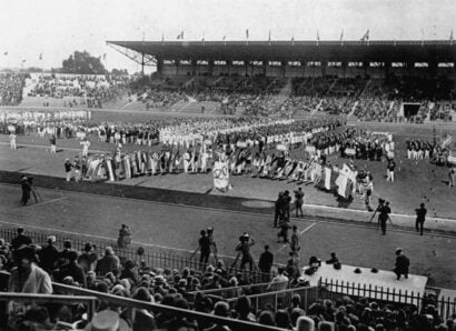 この1924年7月15日のファイル写真は、パリのコロンブスタジアムでの1924年のオリンピックの開幕を示しています。競合するアスリートがフィールドに並び、すべての競合国の旗が、オリンピックの宣誓をしているベテランのフランス人アスリート、G.アンドレの周りに半円を形成しました。AP